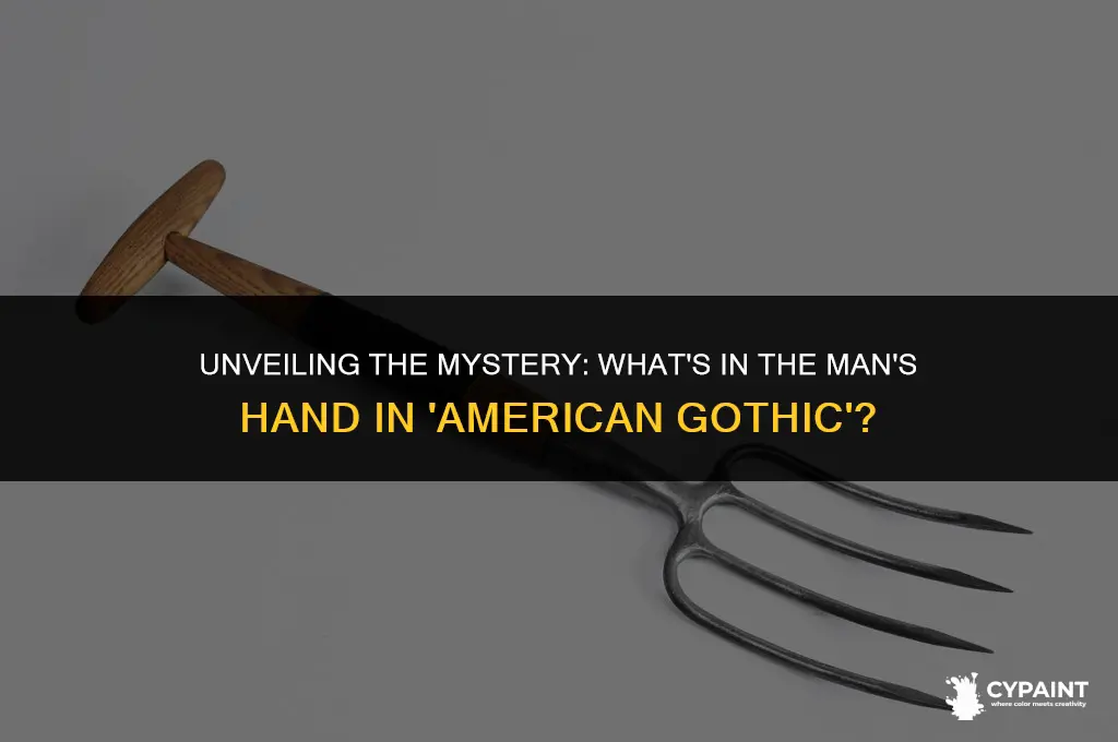 what is the man holding in the american gothic painting